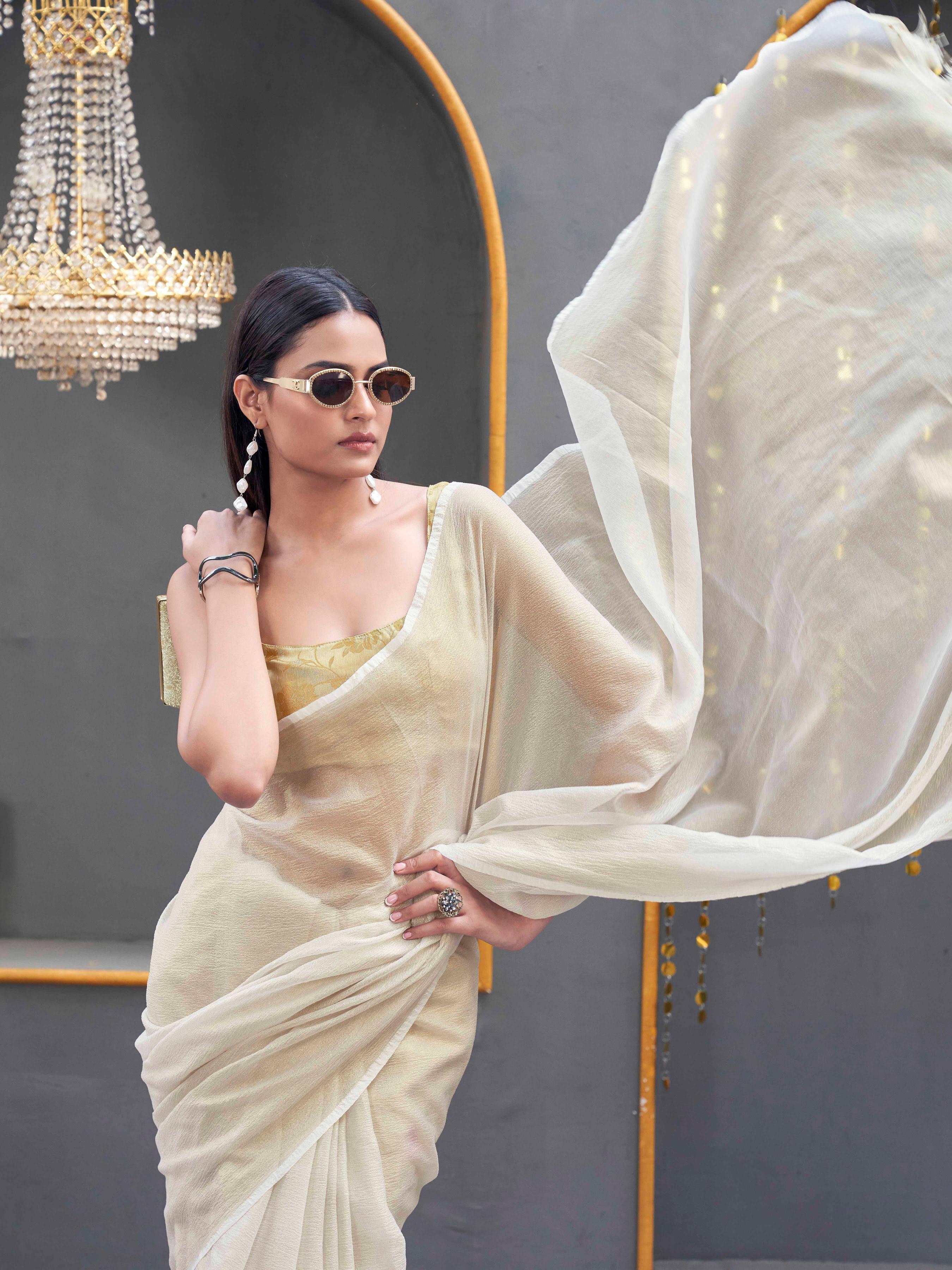 Cream colored designer crunchy saree with tassles on pallu and foil embellishment